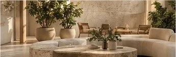 Lounge com sofás claros, mesa de pedra e plantas